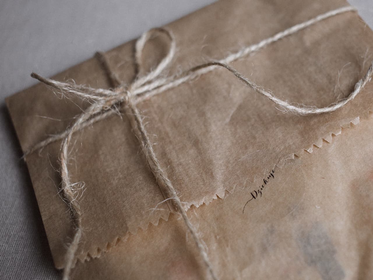 A gift wrapped in plain paper with a cloth ribbon